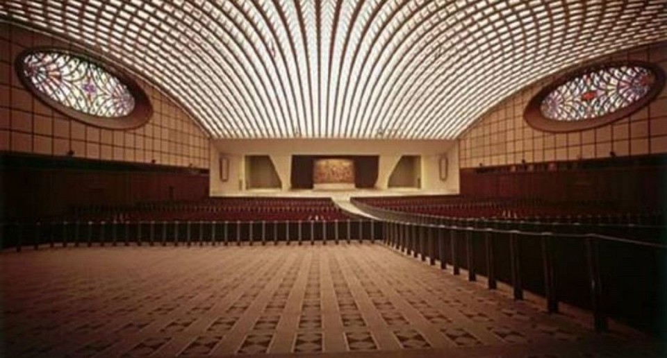 Interior view of the Paul VI Audience Hall. The architecture is designed to resemble the head of a serpent, featuring slitted windows for eyes and a ceiling that mimics scales.